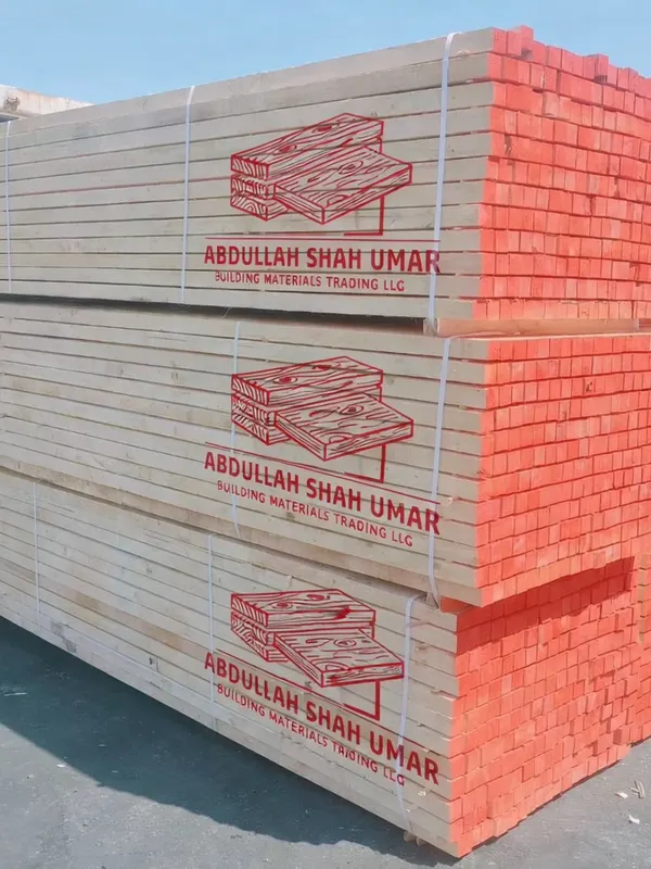 Whitewood bundles printed with the Abdullah Shah Umar logo next to a shipping container